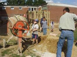 Mit etwas Beton wird das Spielger&auml;t im Boden verankert